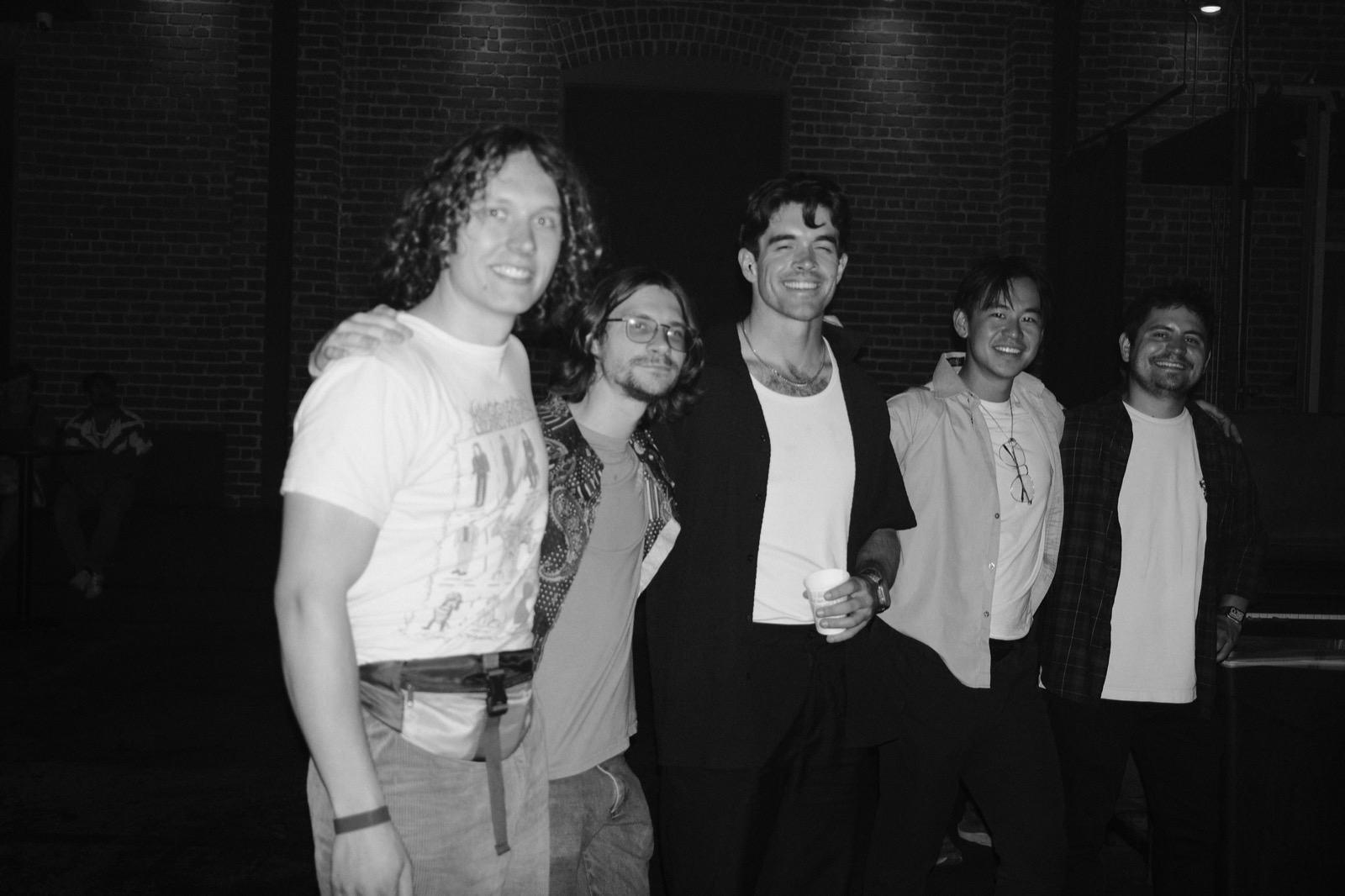 Band members smiling together outside at night