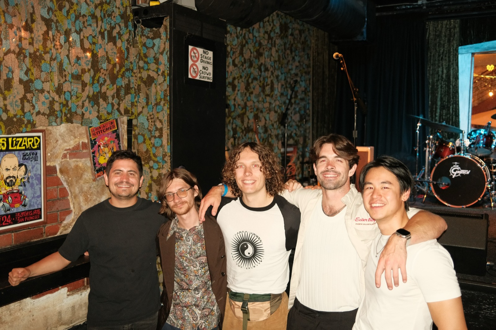 Band posing together at a venue