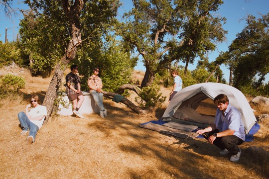 Band hanging out at a campsite under oak trees