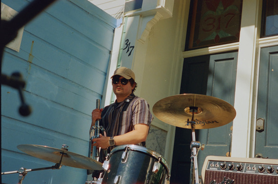 Drummer playing behind the kit on a porch at SF Porchfest