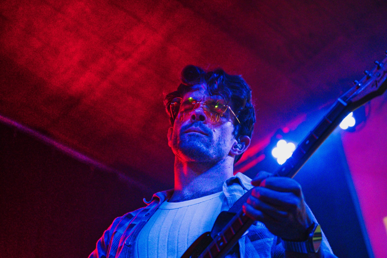 Guitarist playing under red and blue stage lights