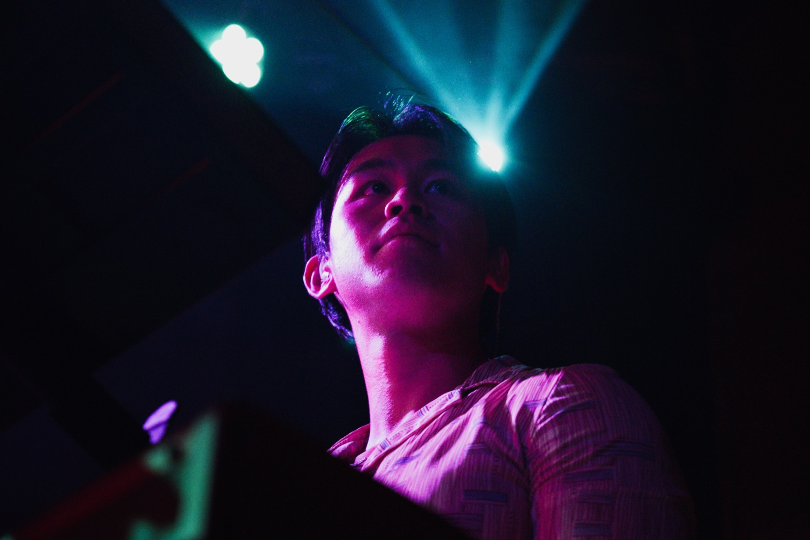Band member looking up under stage lights